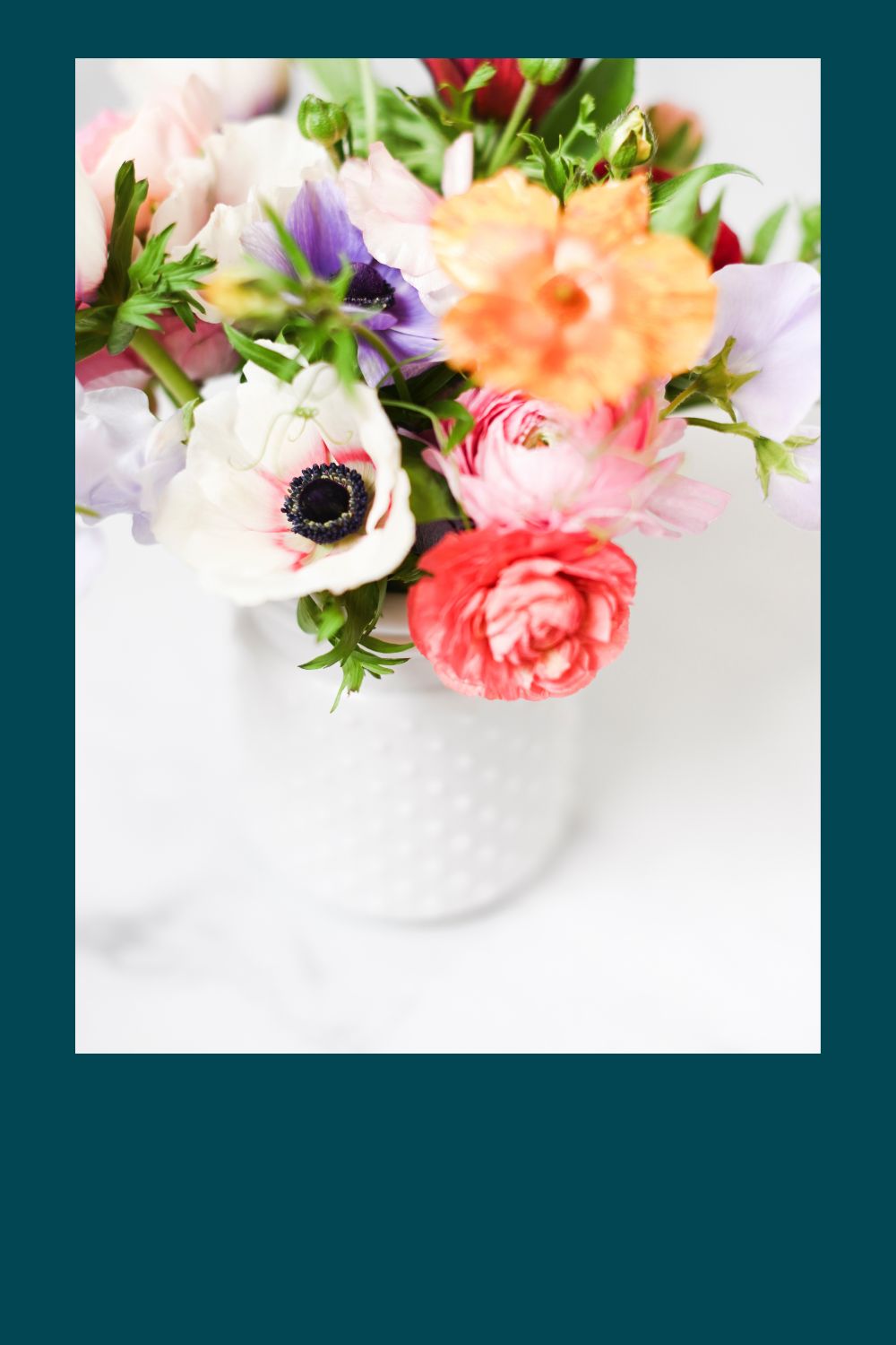 A white vase with multi colored flowers