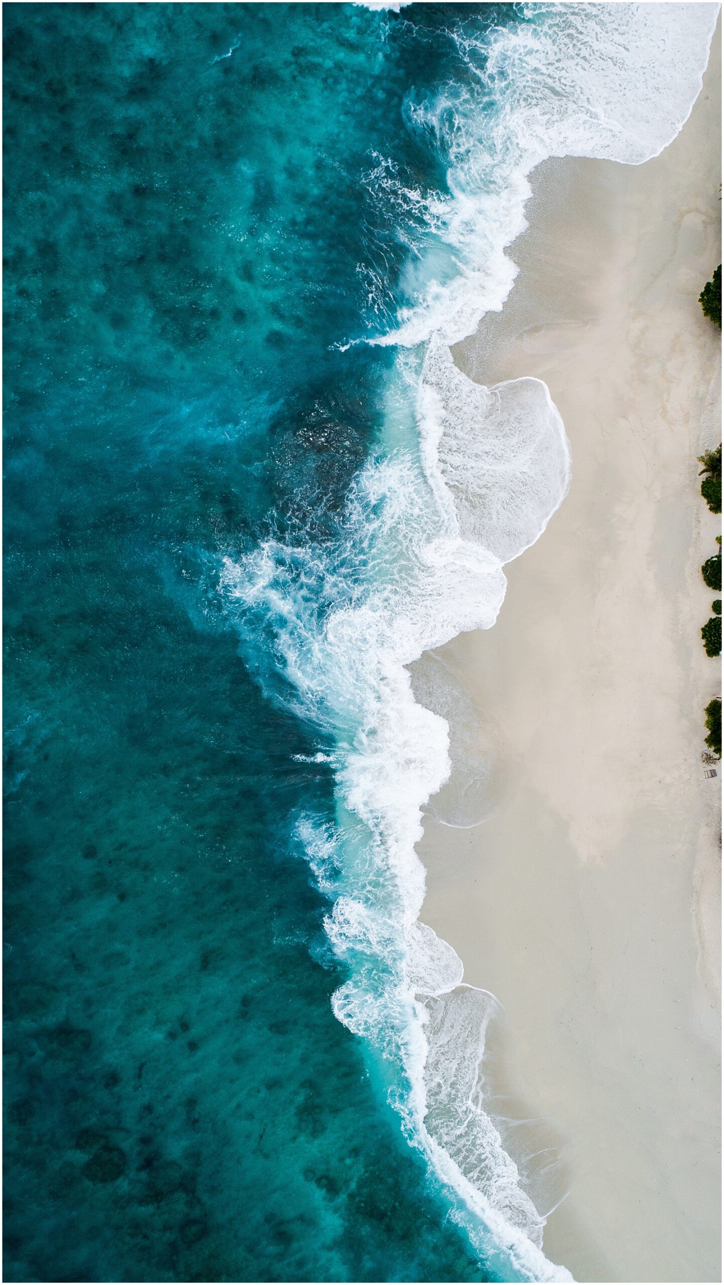 aerial view of turquoise ocean and white sand beach