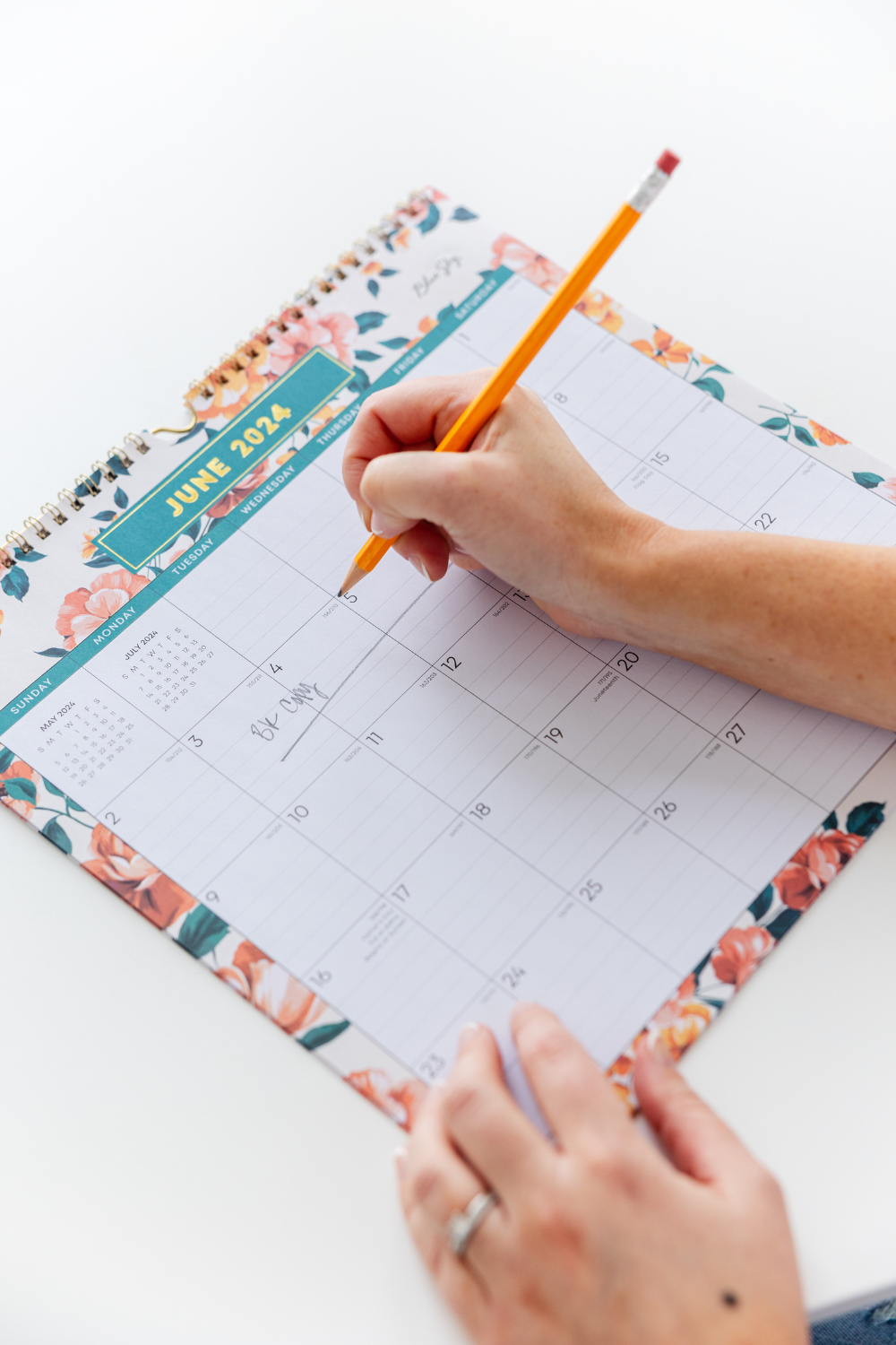 Hand writing in a calendar - how I use HoneyBook to manage my copywriting clients - Rise Copy Co.